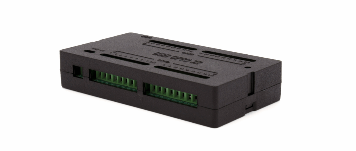 Black rectangular electronic module with two green screw-terminal blocks on the front.